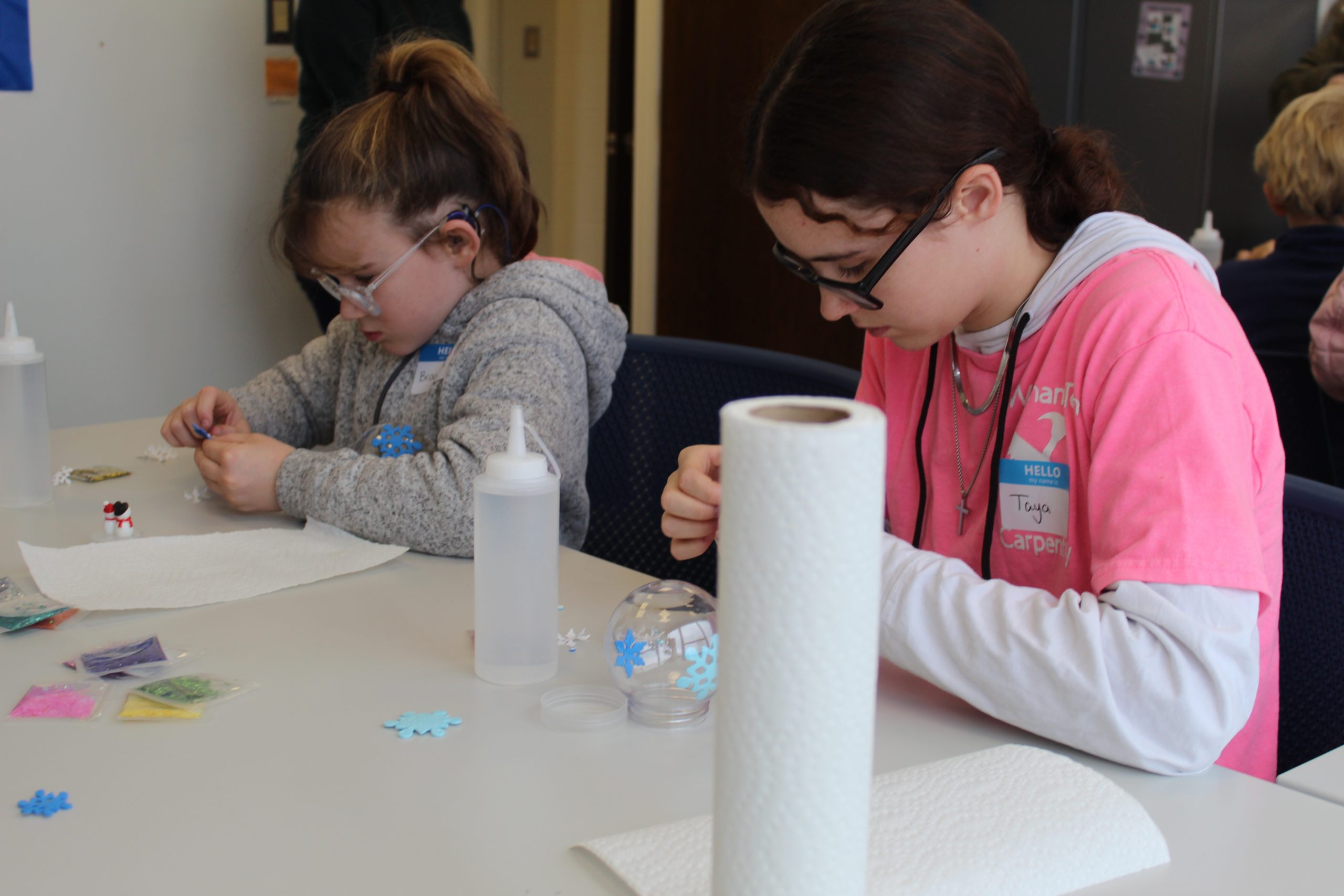 Two children creating homemade snow globes at Winter Wonderland 2024.