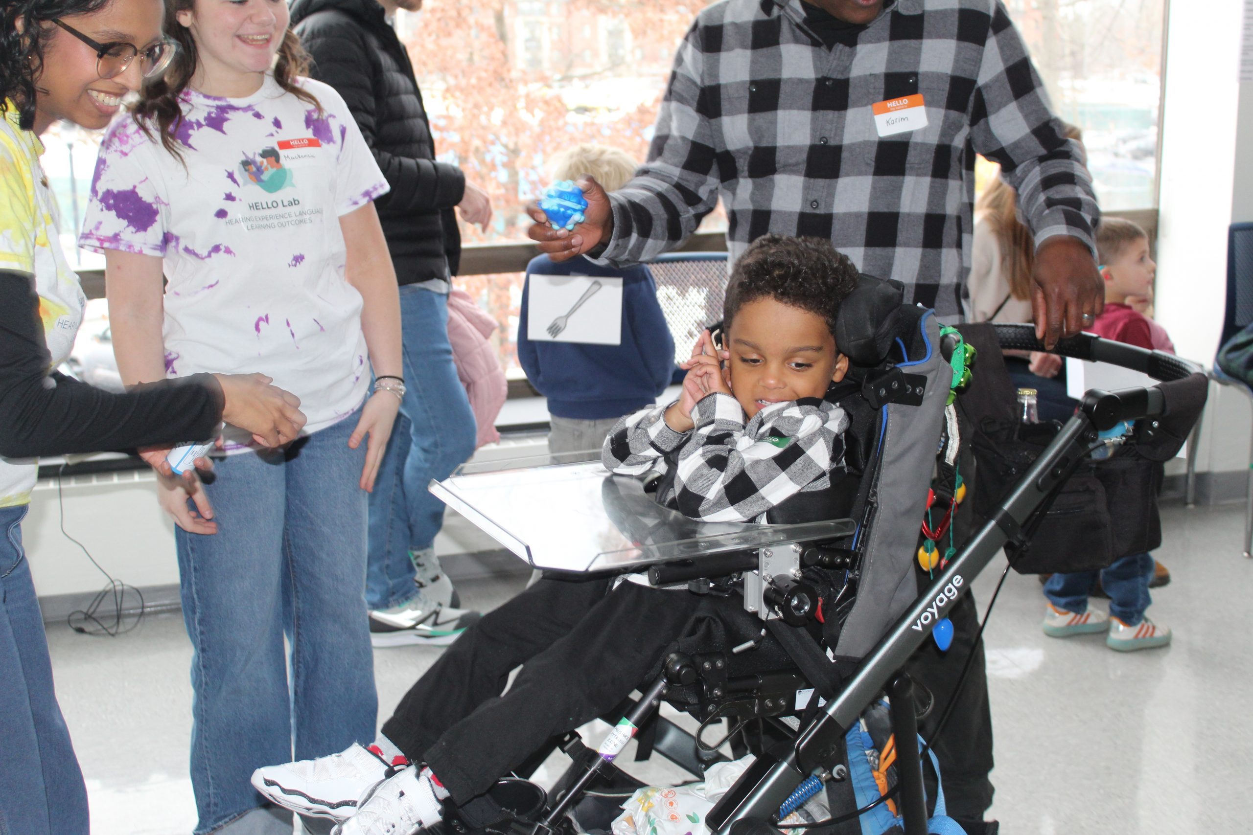 Child in a wheelchair playing matching game at Winter Wonderland 2024.