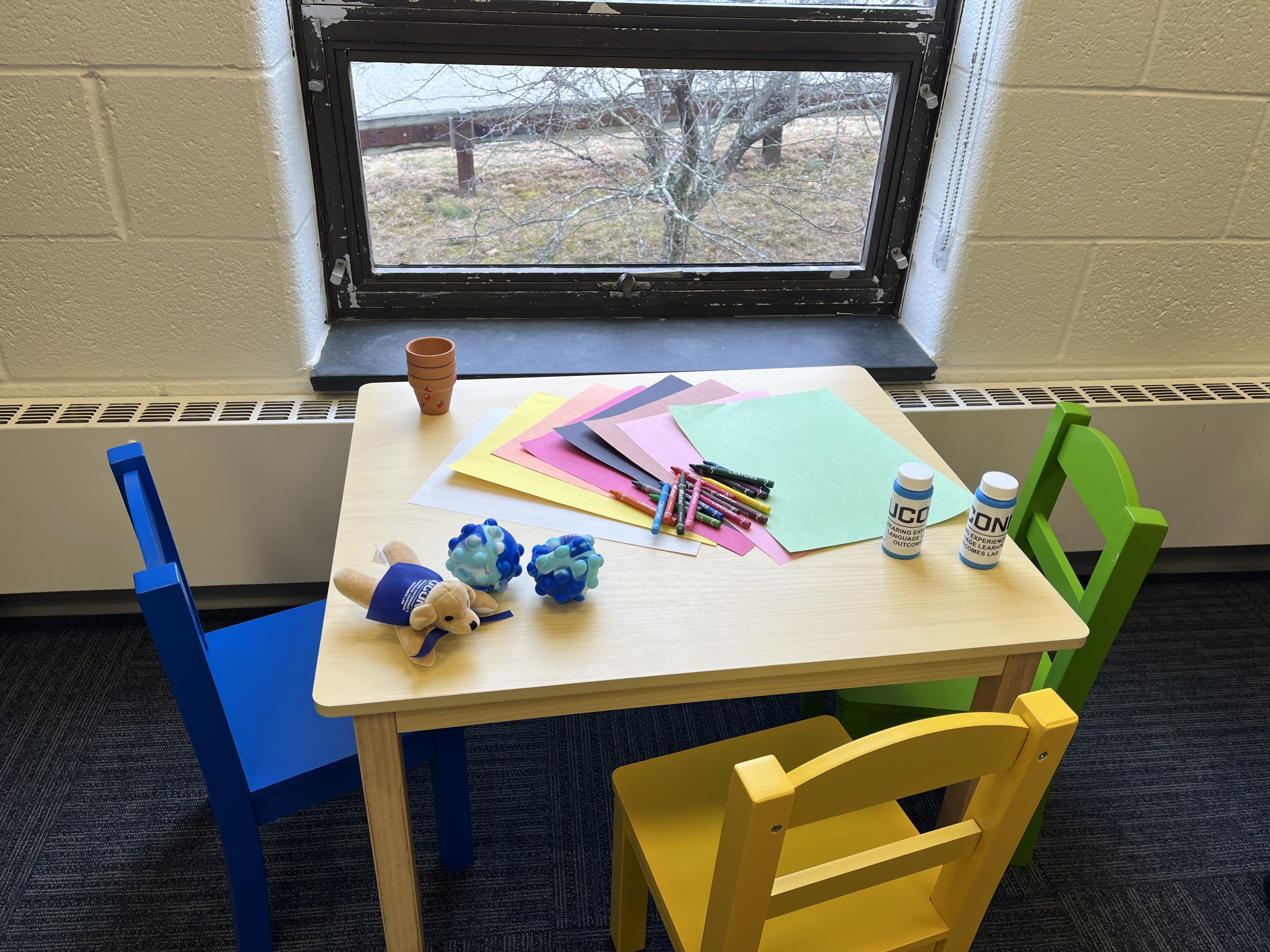 Children activity table with crayons, bubbles, and toys.