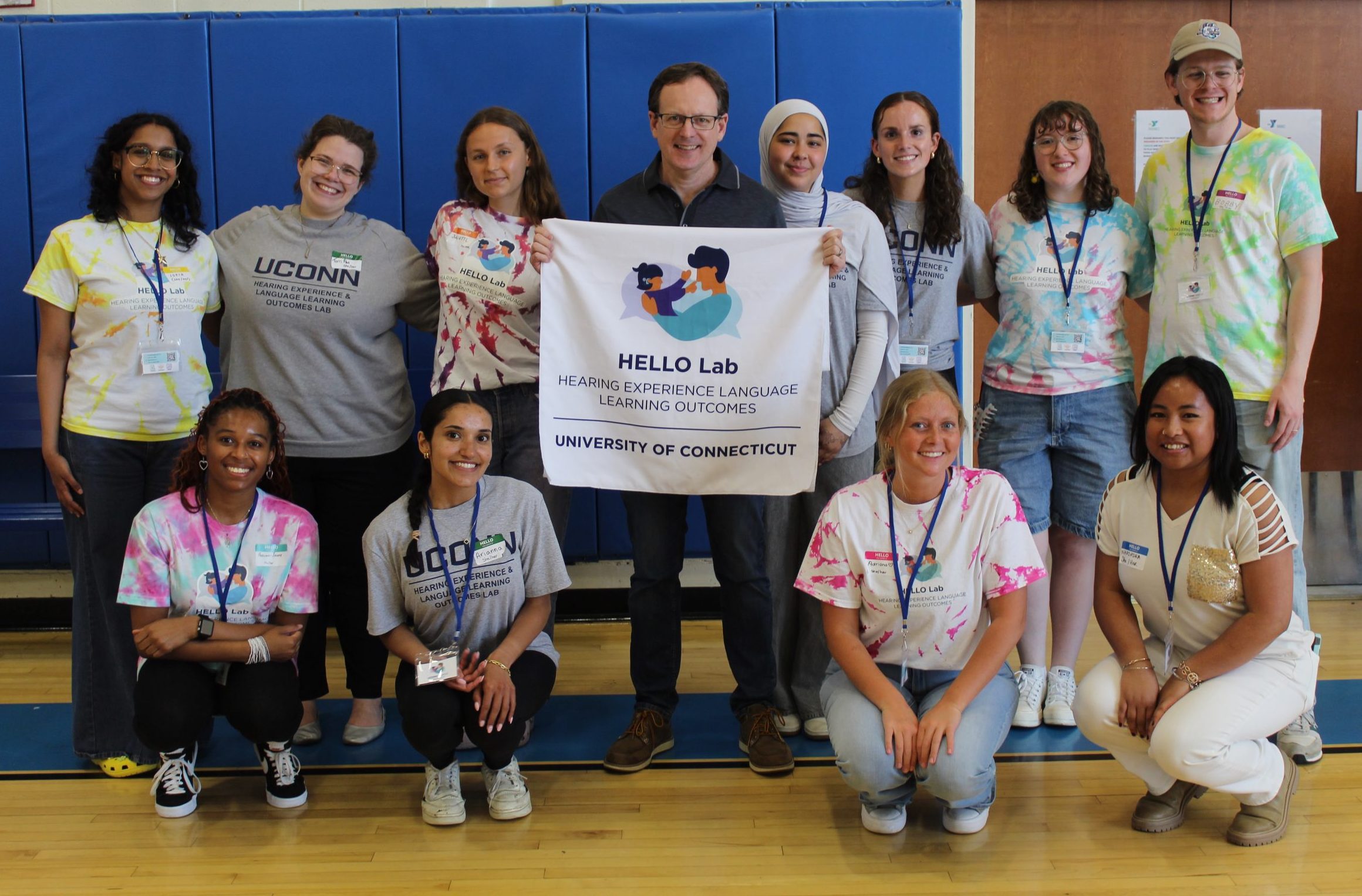 12 HELLO Lab volunteers smiling at the camera and posing for photos.